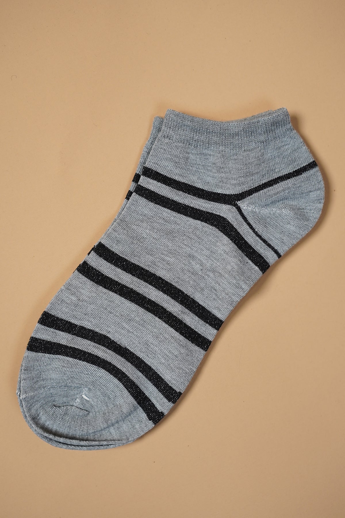 Gray ankle sock with black stripes on a beige background. Main image